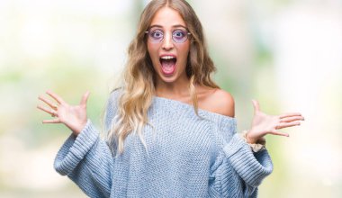 Güzel genç sarışın kadın üzerinde güneş gözlüğü takıyor deli kutluyor arka plan izole ve silah ile başarı için yükseltilmiş ve açık gözleri heyecanlı çığlık hayrete düşürdü. Kazanan kavramı