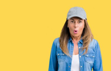 Güzel orta yaş kadın spor şapkası üzerinde arka plan korkuyor ve şok sürpriz ifade, korku ve heyecan yüz ile izole.