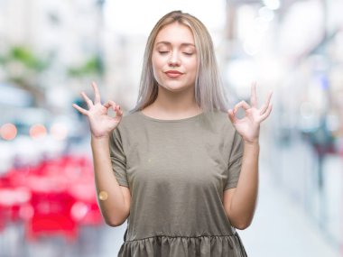 Sarışın genç kadın izole arka plan üzerinde dinlenmek ve gülümseyen gözlerle parmak ile meditasyon jest yapıyor kapalı. Yoga kavramı.