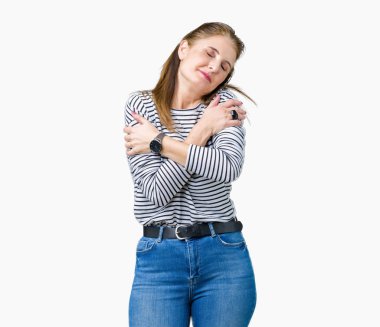 Orta yaş olgun güzel kadın giyiyor çizgili kış kazak izole üzerinde emin gülümseyen Hugging kendini mutlu ve olumlu, arka plan. Kendi aşk ve öz bakım