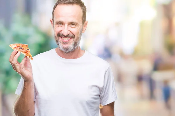 Middle age hoary senior man eating pizza slice over isolated background with a happy face standing and smiling with a confident smile showing teeth