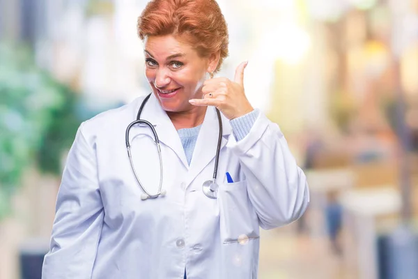 高级白种人医生妇女穿着医疗制服在孤立的背景微笑着做电话手势用手和手指喜欢在电话里说话 传达概念 — 图库照片