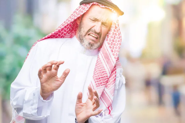 孤立した背景にクーフィーヤを着て年配のアラブ男性うんざり表現で 不快と恐ろしいので嫌悪顔をやって嫌悪反応 手で発生します 迷惑な概念 — ストック写真