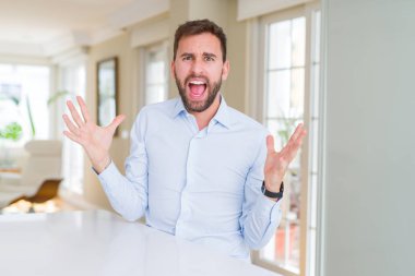 Yakışıklı iş adam çılgın ve kızgın bağırarak ve agresif ifade ve silah kaldırdı bağırıyordu. Hayal kırıklığı kavramı.