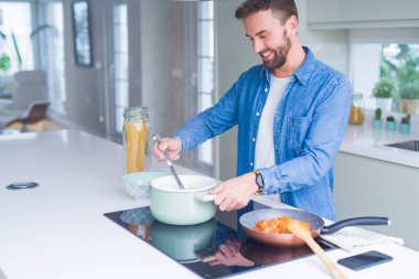 Evde makarna pişiren yakışıklı adam.