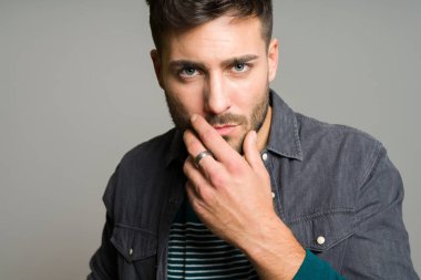 Yakışıklı delikanlı possing ve modelleme gri izole arka plan üzerinde