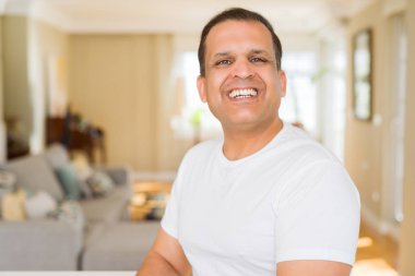 Orta yaş erkek fotoğraf makinesi için evde emin gülümseyen