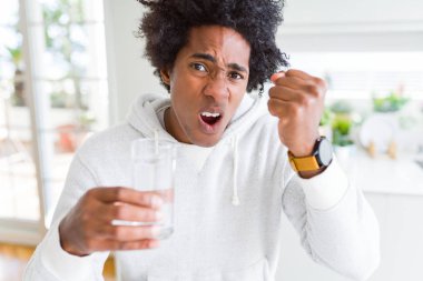Afrika kökenli Amerikalı adam eve rahatsız ve hayal kırıklığı ile öfke, çılgın ve yükseltilmiş eliyle diye bağıran öfke kavramı bağırarak, su içme