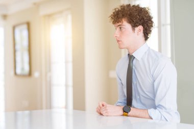 Tarafına, arıyorum bir kravat giyen genç iş adamı dinlenmek doğal yüz emin gülümseme ile pozuyla profili.