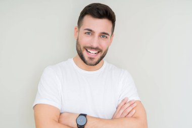 Yakışıklı delikanlı ile izole arka plan mutlu yüz gülümseyen üzerinde rahat beyaz t-shirt giyen silah kameraya bakarak geçti. Olumlu bir kişi.