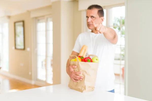 Hombre Mediana Edad Sosteniendo Bolsa Compra Comestibles Casa Señalando Con — Foto de Stock