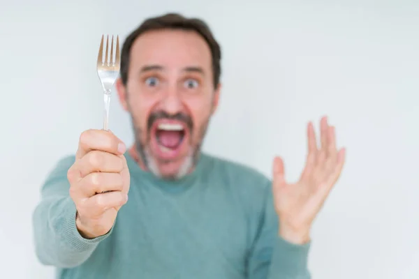 Hombre Mayor Sosteniendo Tenedor Plata Sobre Fondo Aislado Muy Feliz —  Fotos de Stock