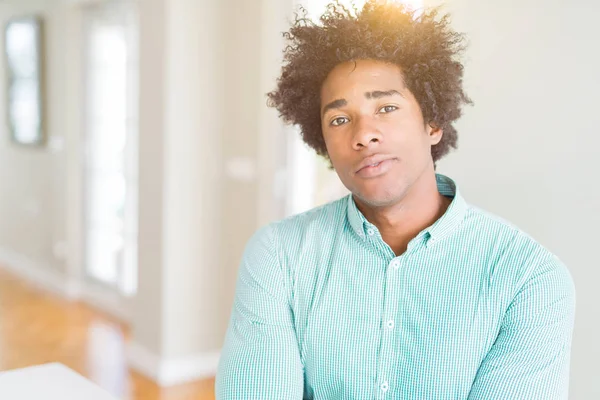 African American business man wearing elegant shirt Relaxed with serious expression on face. Simple and natural with crossed arms