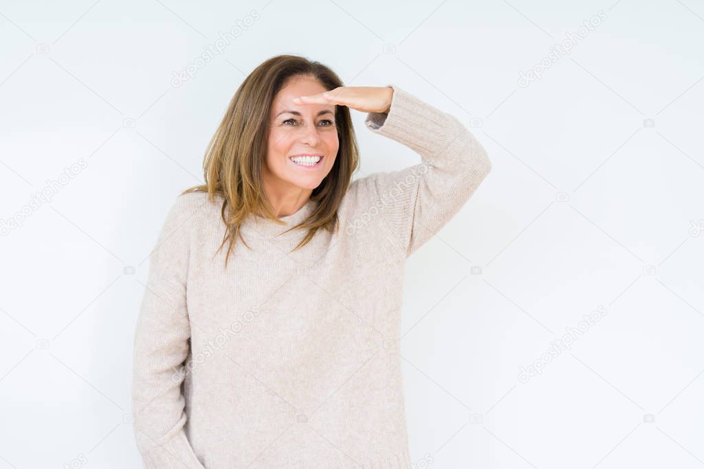 Beautiful middle age woman over isolated background very happy and smiling looking far away with hand over head. Searching concept.