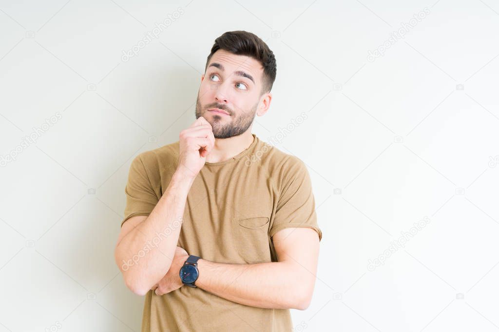 Young handsome man over isolated background with hand on chin thinking about question, pensive expression. Smiling with thoughtful face. Doubt concept.