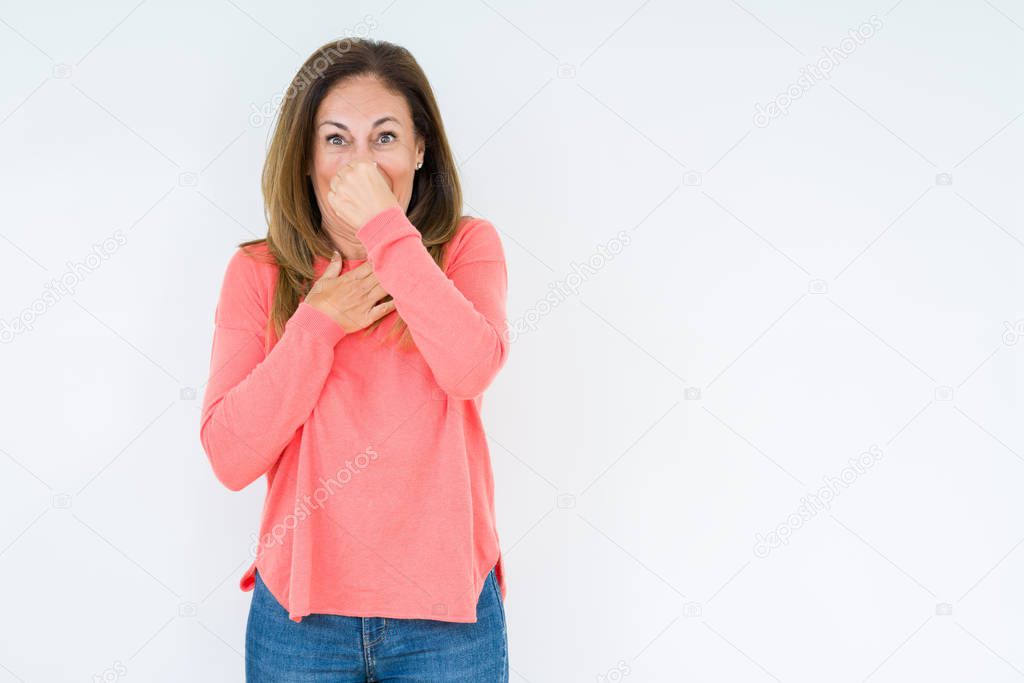 Beautiful middle age woman over isolated background smelling something stinky and disgusting, intolerable smell, holding breath with fingers on nose. Bad smells concept.