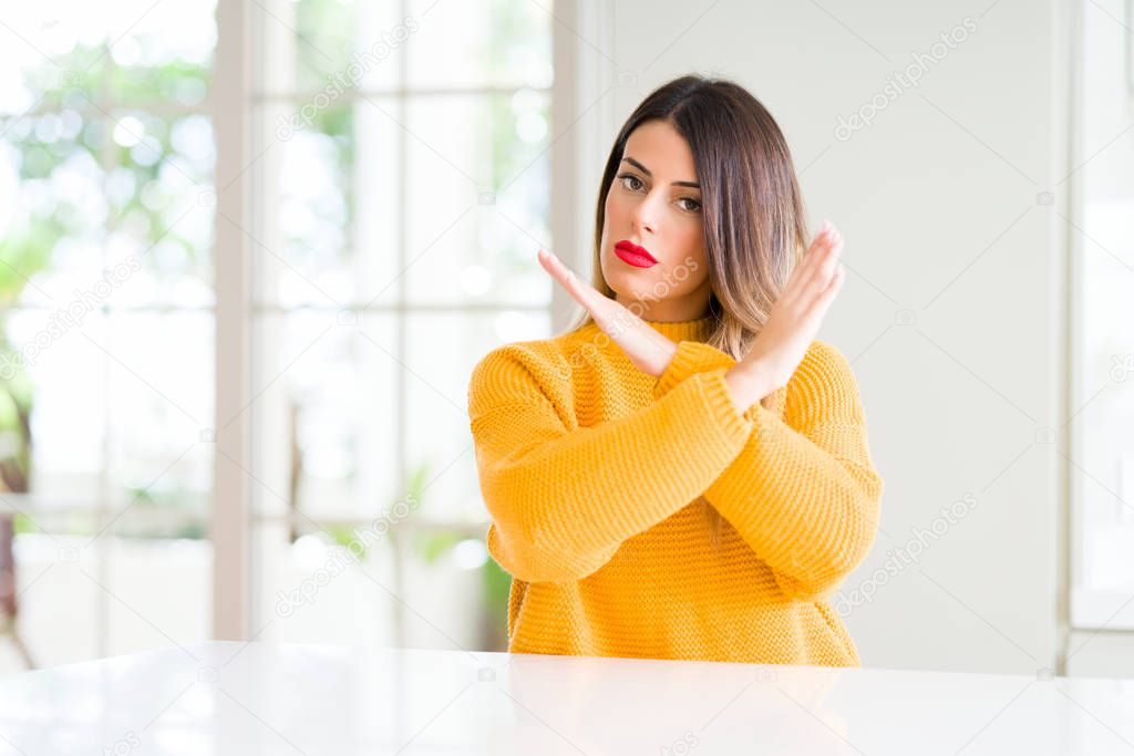 Young beautiful woman wearing winter sweater at home Rejection expression crossing arms doing negative sign, angry face