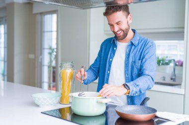 Evde makarna pişiren yakışıklı adam.