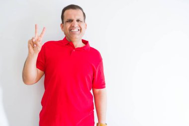 Orta yaş erkek gösterilen ve parmakları ile işaret beyaz duvarın üzerinden kırmızı t-shirt giyen ikincisi ise kendinden emin ve mutlu gülümseyerek.