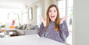 Güzel genç kadın evde çılgın ve başarı için hayran kaldırdı Kollarını açarak kutluyor ve heyecanlı çığlık gözleri açık. Kazanan kavramı