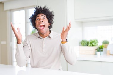 Afrika kökenli Amerikalı adam evde çılgın ve başarı için hayran kaldırdı Kollarını açarak kutluyor ve heyecanlı çığlık gözleri açık. Kazanan kavramı