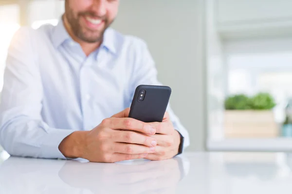 Primer plano de las manos del hombre usando el teléfono inteligente y sonriendo —  Fotos de Stock