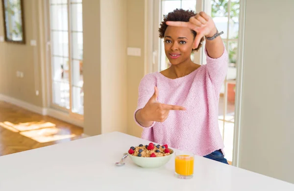 年轻的非洲裔美国妇女在早上在家里吃健康的早餐微笑的框架与手和手指与快乐的脸 创意和摄影理念 — 图库照片