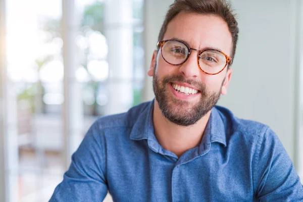 Knappe man dragen van een bril en glimlachend ontspannen op camera — Stockfoto