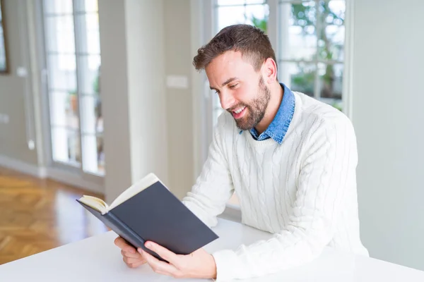 Knappe man die thuis een boek leest — Stockfoto