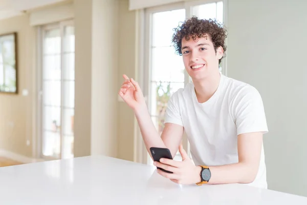 Young Man Using Smartphone Home Very Happy Pointing Hand Finger — Stock Photo, Image