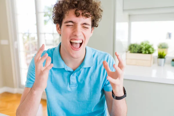 Joven Hombre Guapo Vistiendo Casual Camiseta Azul Casa Celebrando Loco —  Fotos de Stock