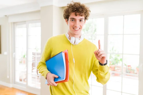 Young Student Man Wearing Headphones Holding Notebooks Surprised Idea Question — Stock Photo, Image