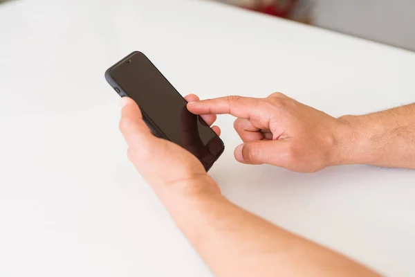 Primer plano de las manos de hombre de mediana edad utilizando el teléfono inteligente en casa —  Fotos de Stock