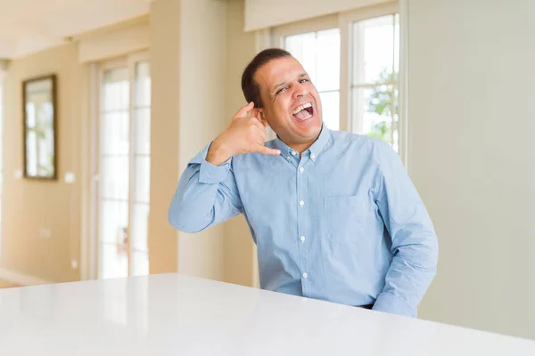 Hombre Mediana Edad Sentado Casa Sonriendo Haciendo Gesto Telefónico Con —  Fotos de Stock