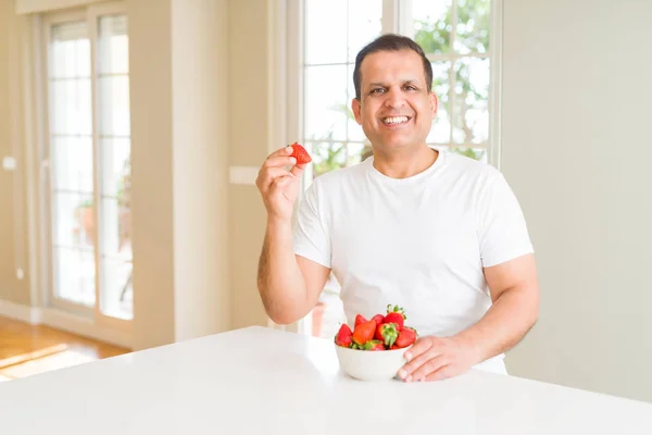 Hombre Mediana Edad Comiendo Fresas Casa Con Una Cara Feliz — Foto de Stock