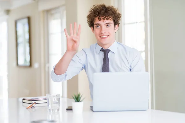 在办公室里用电脑笔记本电脑工作的年轻商人一边微笑着自信和快乐 一边用手指指着四号 — 图库照片