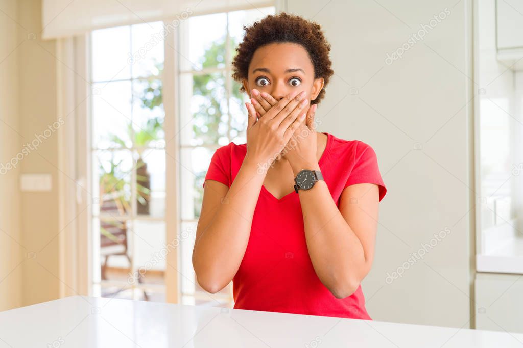 Young beautiful african american woman at home shocked covering mouth with hands for mistake. Secret concept.