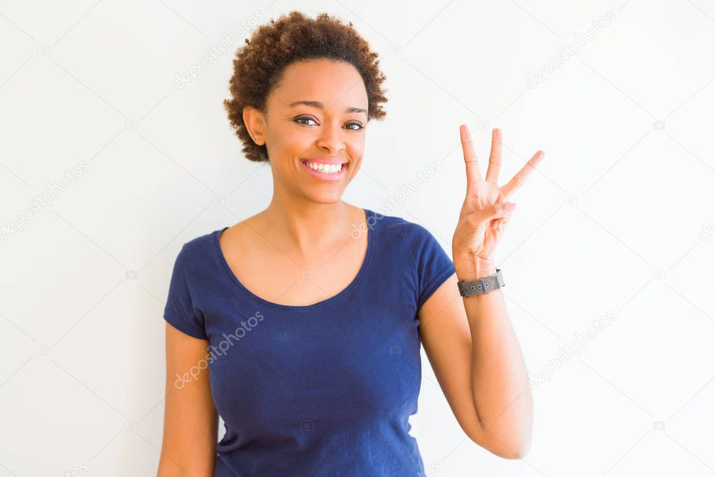 Young beautiful african american woman over white background showing and pointing up with fingers number three while smiling confident and happy.