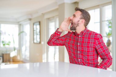 Renkli gömlek bağırarak ve ağzı üzerinde el ile yan için çığlık giyen yakışıklı adam. İletişim kavramı.