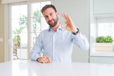 El ve parmak ile ok işareti yapıyor olumlu gülümseyen yakışıklı iş adamı. Başarılı ifade.