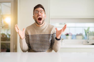 Evde çılgın ve kızgın bağırarak ve agresif ifade ve silah kaldırdı bağırmaya gözlüklü genç yakışıklı adam. Hayal kırıklığı kavramı.