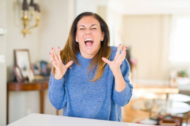 Güzel orta yaş kadın evde deli ve çığlık kaldırdı ve kapalı gözleri heyecanlı silah ile başarı için deli kutluyor. Kazanan kavramı
