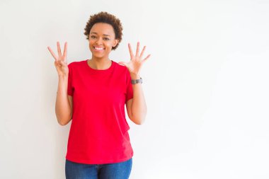 Gösterilen ve parmakları ile işaret beyaz arka plan üzerinde genç güzel bir Afrikalı-Amerikalı kadın kendinden emin ve mutlu gülümseyerek süre sekiz numara.