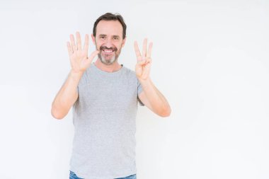 Üst düzey yakışıklı gösteren ve parmakları ile işaret izole arka plan üzerinde kendinden emin ve mutlu gülümseyerek süre sekiz numara.