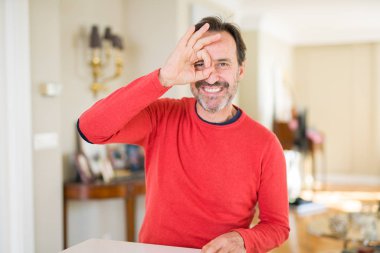 Yakışıklı orta yaş erkek evde el gülümseyen, ok jest yapıyor göz parmakları ile mutlu yüz üzerinden seyir.