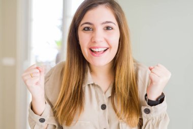 Güzel genç kadın, evde geçirilen silahlarla şaşırmış ve başarı için hayran kutluyor ve gözleri açık. Kazanan kavramı.