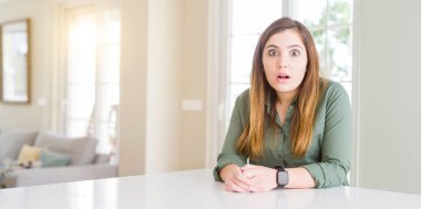 Güzel genç kadın evde korkuyor ve sürpriz ifade ile şok korku ve yüz heyecanlı.