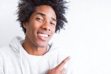 Afrika kökenli Amerikalı adam beyaz izole arka plan neşeli bir gülümseme ile el ve parmak kadar yan yüzünde mutlu ve doğal ifade ile işaret eden yüz