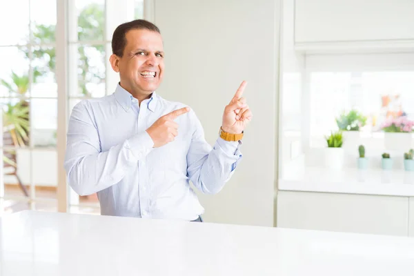 Hombre Mediana Edad Sentado Casa Sonriendo Mirando Cámara Apuntando Con — Foto de Stock