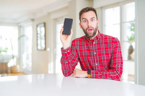 Handsome Man Showing Smartphone Screen Scared Shock Surprise Face Afraid — Stock Photo, Image